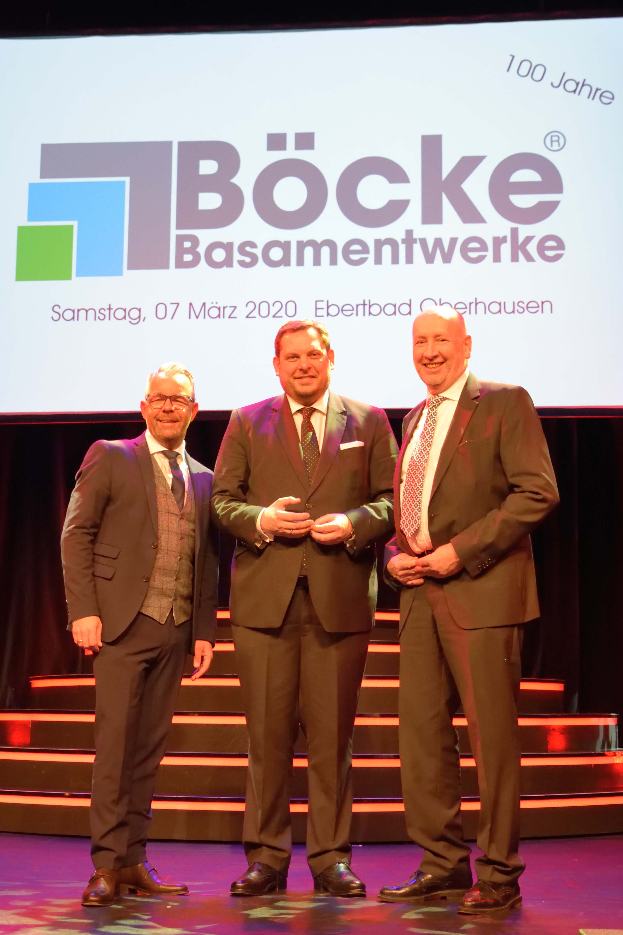 Jubiläum: 100 Jahre Basamentwerke Böcke GmbH

Duisburg, 6. April 2020

Am 7. März 2020 feierte die Basamentwerke Böcke GmbH ihr 100-jähriges Firmenjubiläum im Oberhausener Ebertbad. Zu den Gästen gehörten, neben allen Mitarbeiter/innen und Ehemaligen, auch Daniel Schranz, Oberbürgermeister der Stadt Oberhausen, sowie Raimo Benger, vero-Hauptgeschäftsführer.

Der Gastgeber des Abends, Dr. Thomas Böcke, hielt die Festrede zum Jubiläum. Die imposante Bilderzeitreise durch die letzten 100 Jahre des Basamentwerkes Böcke wurde ergänzt durch ein unterhaltsames Rahmenprogramm mit Zauberern, Musik und Comedy.

Auch vero-Hauptgeschäftsführer Raimo Benger gratulierte dem Mitgliedsunternehmen. „Glückwünsche an ein innovatives Unternehmen, das seit hundert 100 Jahren sichere Arbeits- und Ausbildungsplätze in der Region sichert“, so Benger in seiner Laudatio.

Von seinen Mitarbeitern und Mitarbeiterinnen erhielt der Thomas Böcke ein Präsent in Form einer Betonplatte mit dem aktuellen Firmenlogo und Gravur. Ein gemeinsames Gruppenbild mit allen aktiven Mitarbeitern und Mitarbeiterinnen war der Höhepunkt des Abends. „Gemeinsamkeit und Zusammenhalt ist uns wichtig. Dieses Bild steht symbolisch dafür. Es ziert unsere Danksagungskarten und wird künftig auch in allen Standorten an den Wänden hängen“, so Thomas Böcke.

Web Pressefoto Gruppenfoto Basamentwerke Boecke

Starker Zusammenhalt: Gruppenbild aller aktiven Mitarbeiter/innen der Basamentwerke Böcke GmbH

Web Pressefoto Jubilaeum Basamentwerke Boecke

(v.l.n.r.) Oliver Nuth, Geschäftsführer Böcke, Daniel Schranz, Oberbürgermeister der Stadt Oberhausen, Dr. Thomas Böcke, Geschäftsführer Böcke